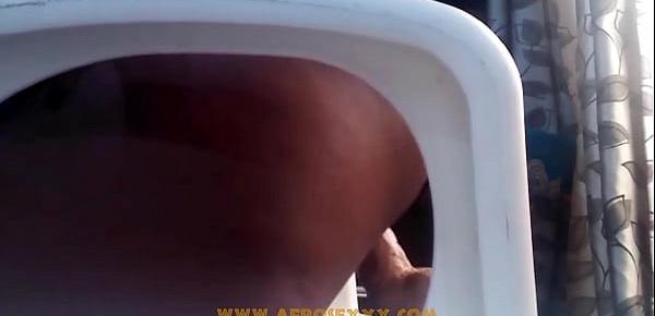  African with mini skirt fucks herself with a toy on the chair